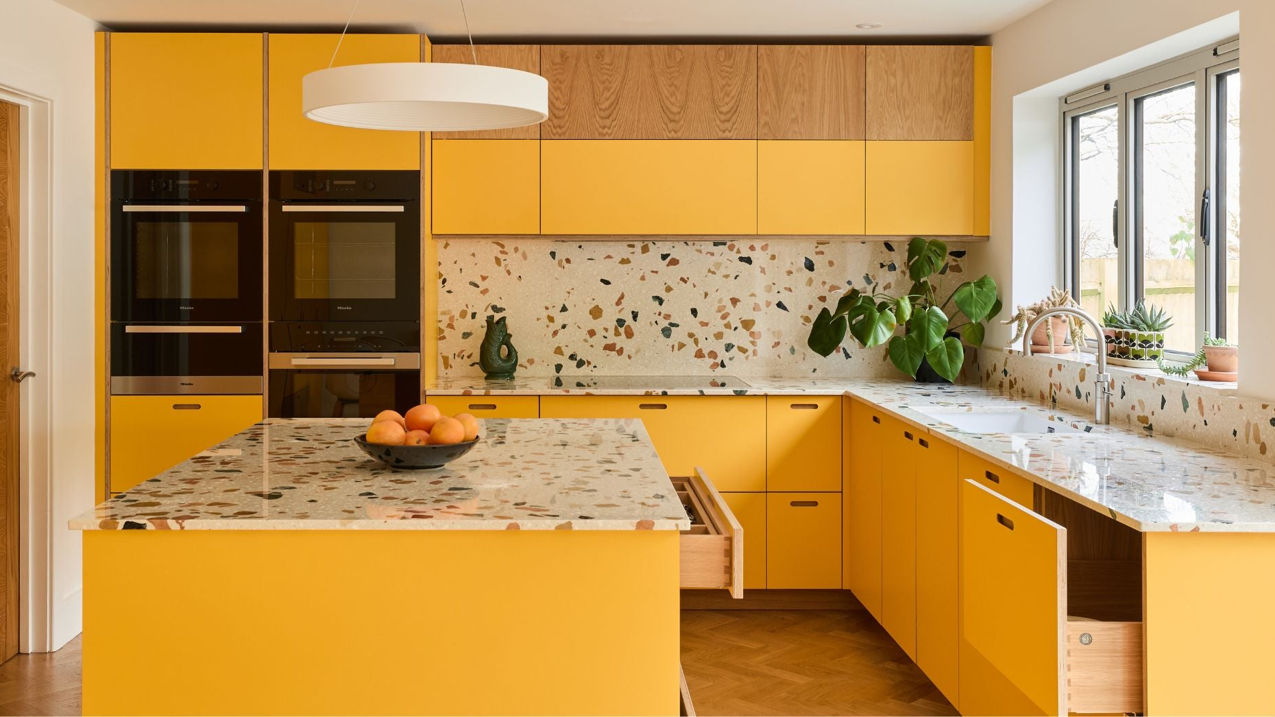 Modern kitchen with yellow cabinets and a central island.