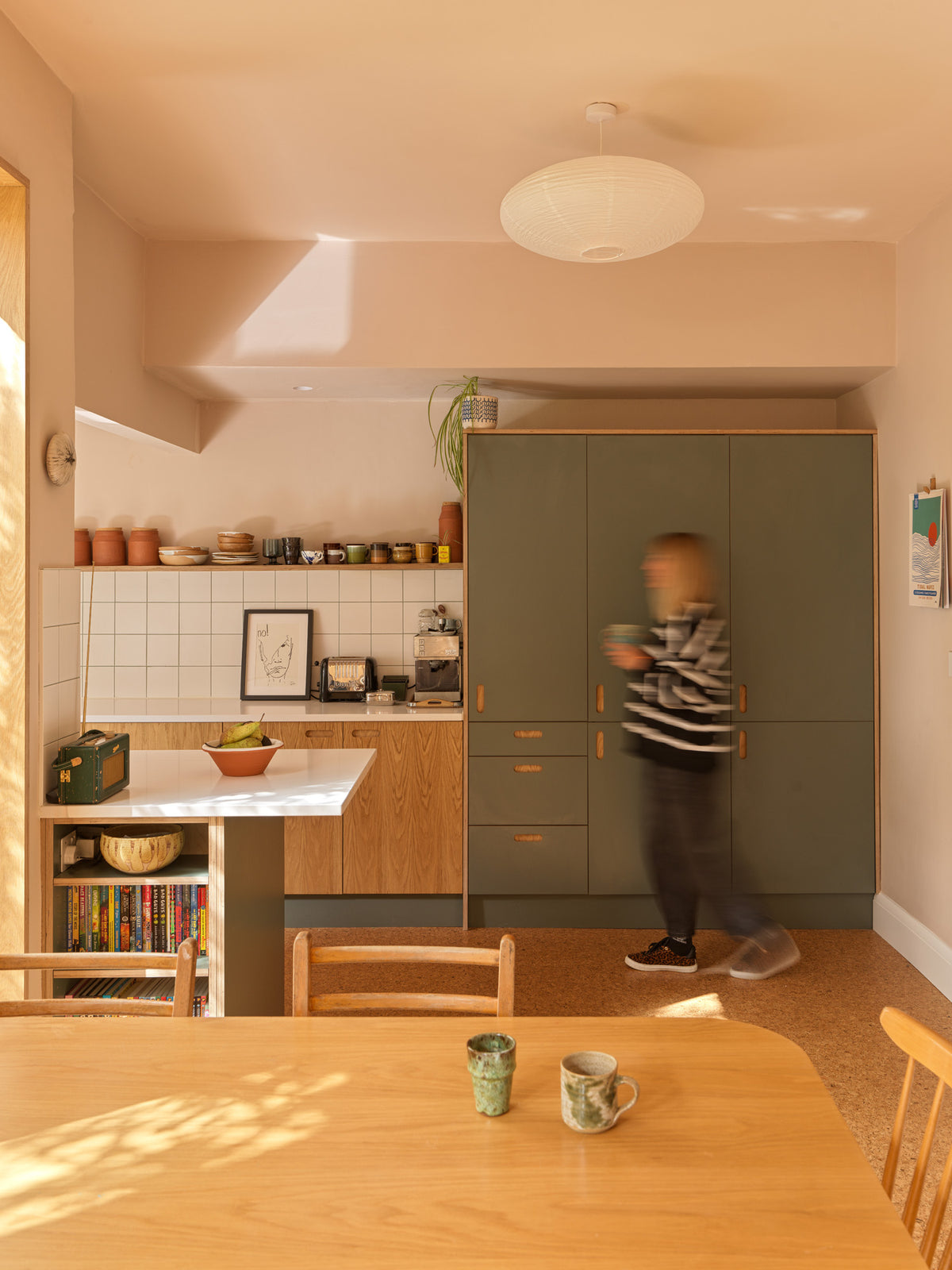 A Wren kitchen transformed with Green Slate Formica and oak plywood fronts, bespoke shelving, island bookshelves and a custom sliding door.